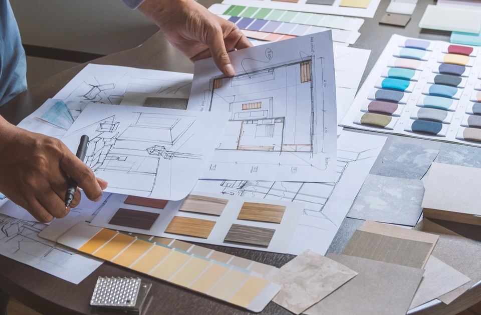 Scène d'intérieur avec deux personnes consultant des plans d'architecture sur parquet bois