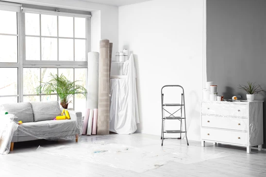 Intérieur d'atelier, artisan posant carrelage blanc sur sol, mains expertes positionnant carreau avec précision