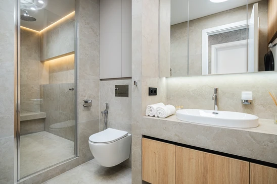Salle de bain moderne avec vasque à poser ronde en céramique blanche sur plan de travail en bois massif